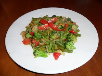 a white plate of food with broccoli and peppers at Posada El Tesin in Rabanal del Camino