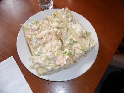 a white plate with a slice of pizza on a table at Posada El Tesin in Rabanal del Camino
