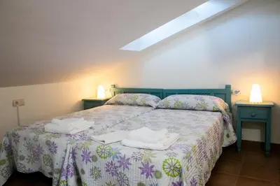 a bedroom with a bed with two towels on it at Posada El Tesin in Rabanal del Camino