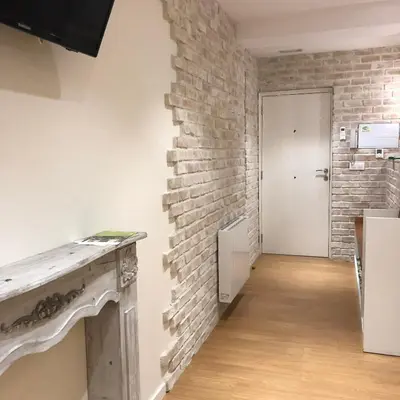 an empty room with a brick wall and a door at Rentxacobeo in Sarria