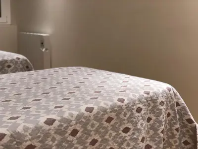 a bed with a quilt on it in a room at Rentxacobeo in Sarria