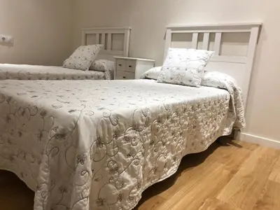 a bedroom with a bed with a white comforter at Rentxacobeo in Sarria