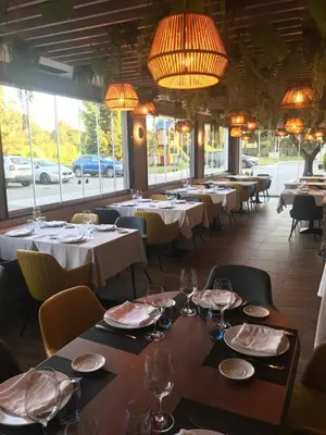 a restaurant with white tables and chairs and windows at Coto Real in Rábade