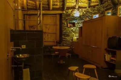 a room with stools and a table and a tv at Palloza Baltasar in Castelo