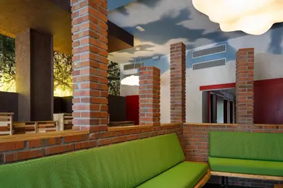 a room with a green couch on a brick wall at Blanco Albergue in Santiago de Compostela