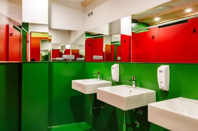 a bathroom with two sinks and red and green cabinets at Blanco Albergue in Santiago de Compostela