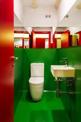 a green bathroom with a toilet and a sink at Blanco Albergue in Santiago de Compostela