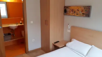a bedroom with a bed and a sink and a mirror at Blanco Albergue in Santiago de Compostela