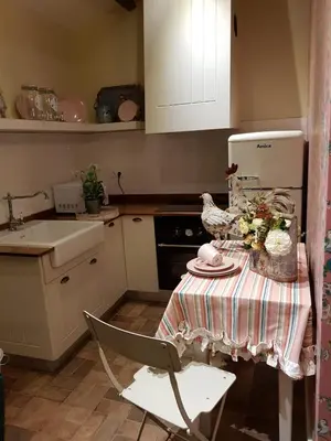 a kitchen with a table with a chicken and flowers on it at La Calleja in Arzúa