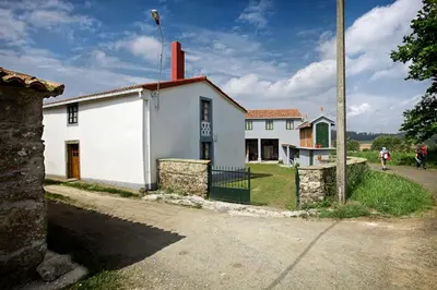 a white house with a red chimney on top of it at La Calleja in Arzúa