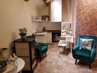 a living room with two chairs and a table and a kitchen at La Calleja in Arzúa