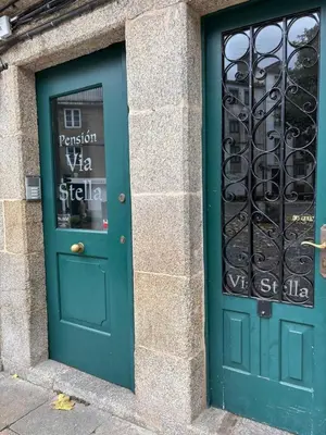 a green door on a building with a gate at Pension Via-Stella in Santiago de Compostela