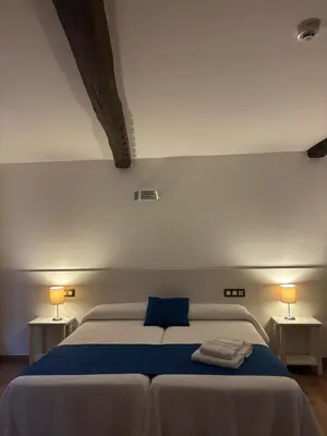 a bedroom with a bed with two lamps on two tables at Pension Via-Stella in Santiago de Compostela