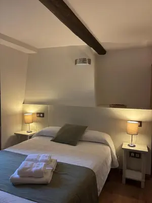 a bedroom with two beds and two lamps on tables at Pension Via-Stella in Santiago de Compostela