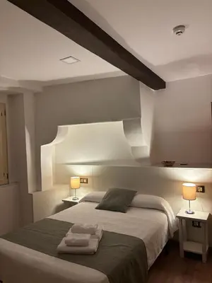 a bedroom with a bed with two towels on it at Pension Via-Stella in Santiago de Compostela