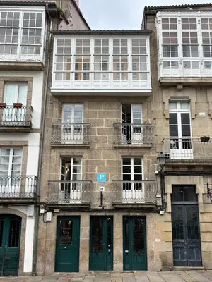 a large building with green doors and windows at Pension Via-Stella in Santiago de Compostela