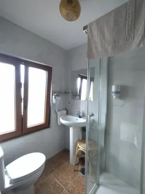 a bathroom with a sink and a toilet and a shower at Hostal Restaurante Parajes in Castropol