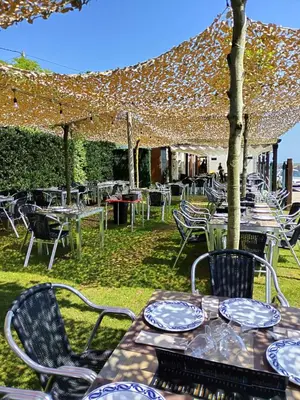 a group of tables and chairs under an umbrella at Hostal Restaurante Parajes in Castropol