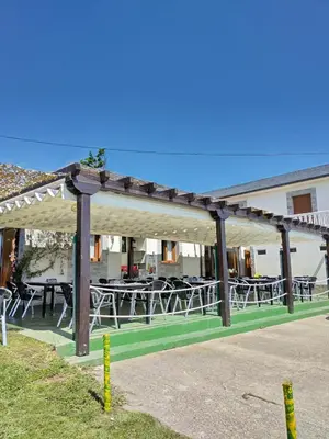 a restaurant with tables and chairs with red and white table cloth at Hostal Restaurante Parajes in Castropol