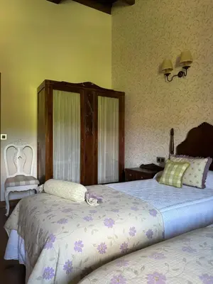 a bedroom with two beds and a chair at A Eira da Laxe in Cerdedo