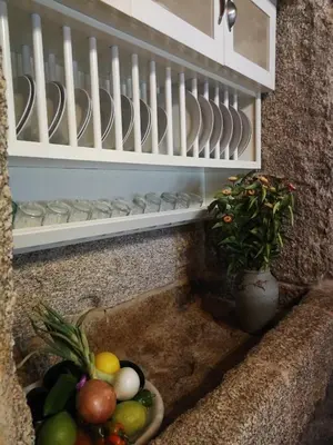 a kitchen sink with a bowl of fruit and a plant at A Eira da Laxe in Cerdedo