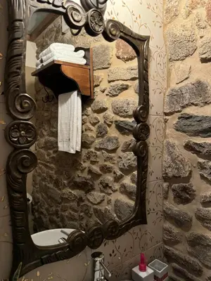 a bathroom with a mirror on a stone wall at A Eira da Laxe in Cerdedo