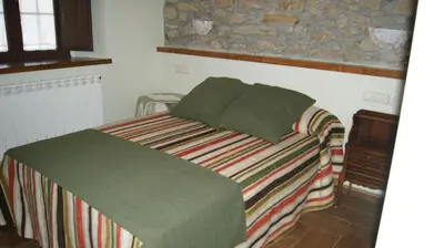 a bedroom with a bed with a green blanket at Casa rural el Molino del Botero in Coso