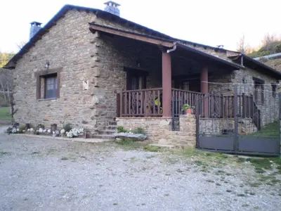 a brick house with a porch and a fence at Casa rural el Molino del Botero in Coso