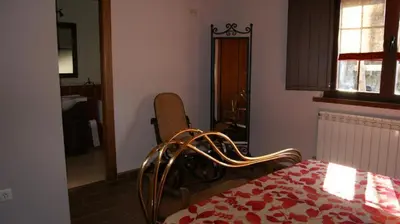 a bedroom with a bed and a window and a chair at Casa rural el Molino del Botero in Coso