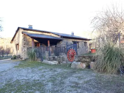 a stone house with a gate and a fence at Casa rural el Molino del Botero in Coso