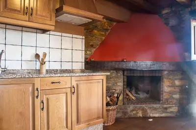 a kitchen with a stone fireplace in a kitchen at Apartamentos rurales Vilarchao in Vilarchao