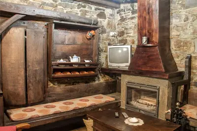 a living room with a fireplace and a tv at Apartamentos rurales Vilarchao in Vilarchao