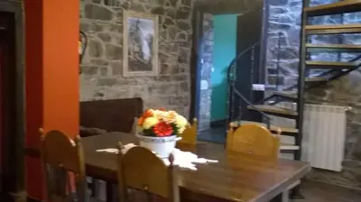 a dining room table with a vase of flowers on it at Apartamentos rurales Vilarchao in Vilarchao