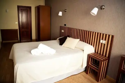 a bedroom with a large white bed with two pillows at Hotel Villa De Ribadeo in Ribadeo