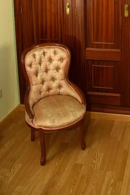 a chair in a room with a wooden wall at Hotel Villa De Ribadeo in Ribadeo