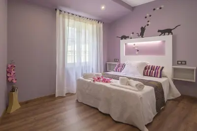 a bedroom with a large bed with pink walls at Casa Carla in Palas de Rei
