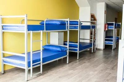 a room with three bunk beds with blue pillows at De Camino in Arzúa