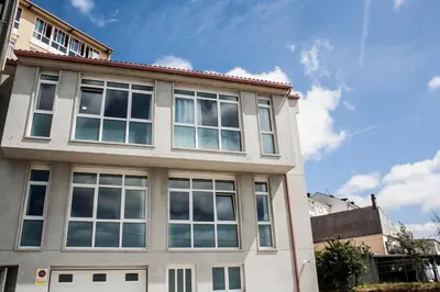 a building with many windows on the side of it at De Camino in Arzúa