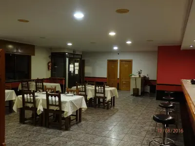 a dining room with tables and chairs in a restaurant at Pension Meson Paz in Puentedeume