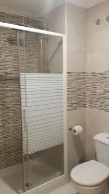 a bathroom with a toilet and a glass shower at Monqar in Foz