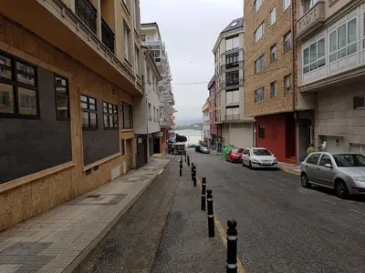 a city street with a row of poles on the sidewalk at Monqar in Foz