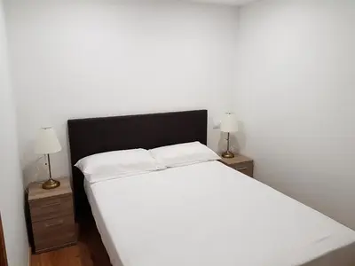a white bed with two night stands and two lamps at Monqar in Foz