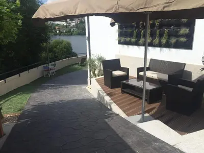 a patio with a table and chairs under an umbrella at A Fontana de Luxo Apartamentos in Portomarin