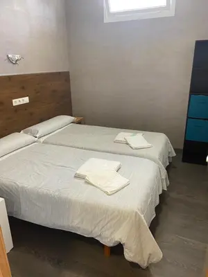 two beds in a room with towels on them at A Fontana de Luxo Apartamentos in Portomarin