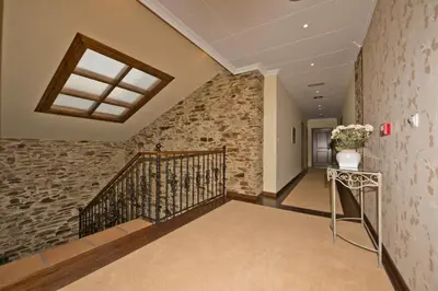 a staircase in a house with a stone wall at La Casona de Lazúrtegui in Ribadeo