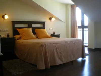 a bedroom with a large bed with yellow pillows at La Casona de Lazúrtegui in Ribadeo