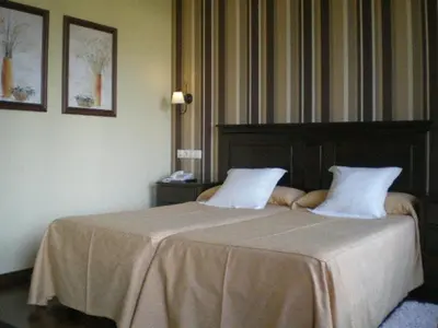 a bedroom with a bed with two pillows on it at La Casona de Lazúrtegui in Ribadeo