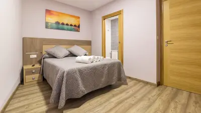 a bedroom with a bed and a wooden floor at Pensión Pereiro in Melide