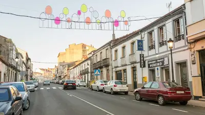 a busy city street with cars parked on the street at Pensión Pereiro in Melide