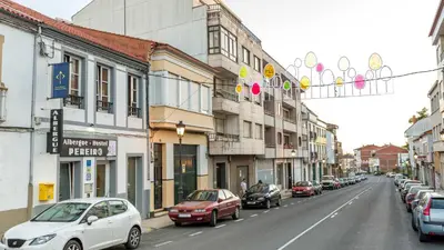 a street with cars parked on the side of the road at Pensión Pereiro in Melide
